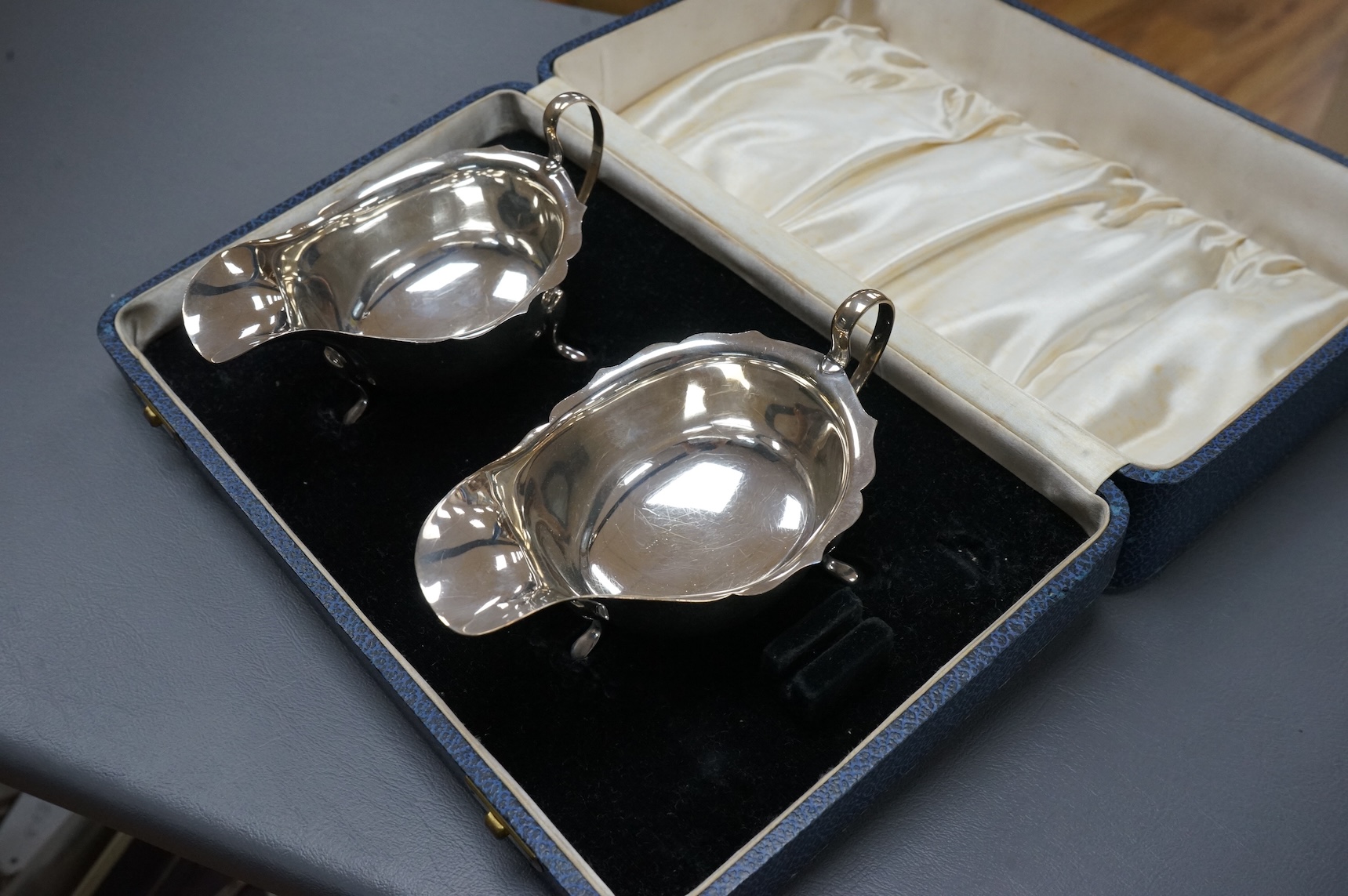 A pair of George VI silver sauce boats, maker, ENC, Sheffield, 1937, in fitted case (lacking sauce ladles?), length 14.6oz, 7oz.